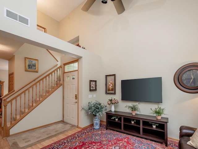 6388 Tahoe Rd, Woodbury, MN 55125 - living room with stairway, wood finished floors, a ceiling fan, and a high ceiling