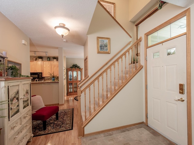 6388 Tahoe Rd, Woodbury, MN 55125 - foyer with stairs, light wood-style flooring, and a textured ceiling