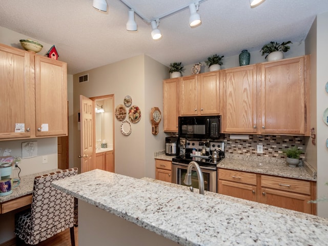 6388 Tahoe Rd, Woodbury, MN 55125 - kitchen with black microwave, stainless steel range with electric cooktop, track lighting, decorative backsplash, and wood finished floors
