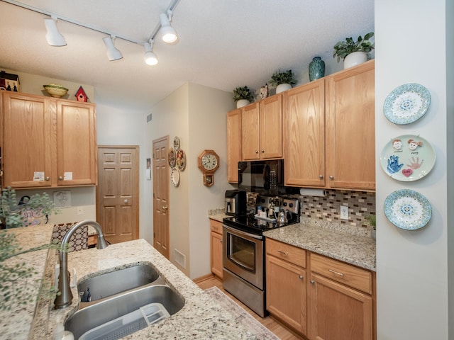 6388 Tahoe Rd, Woodbury, MN 55125 - kitchen with stainless steel electric stove, black microwave, backsplash, track lighting, and light stone countertops