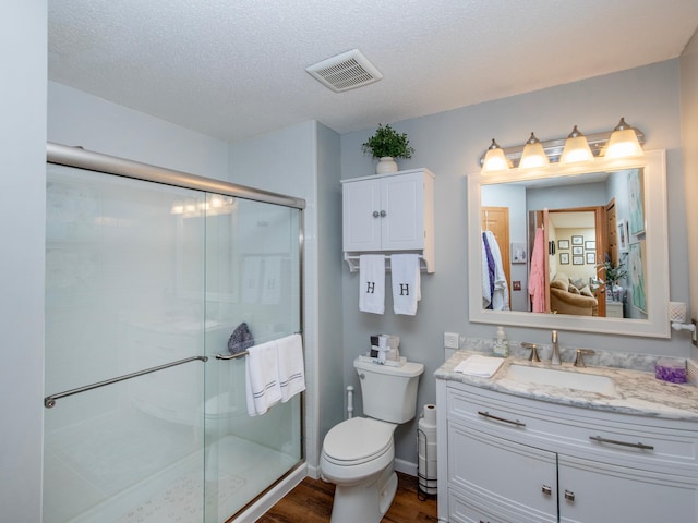 6388 Tahoe Rd, Woodbury, MN 55125 - full bathroom with wood finished floors, a stall shower, vanity, and a textured ceiling