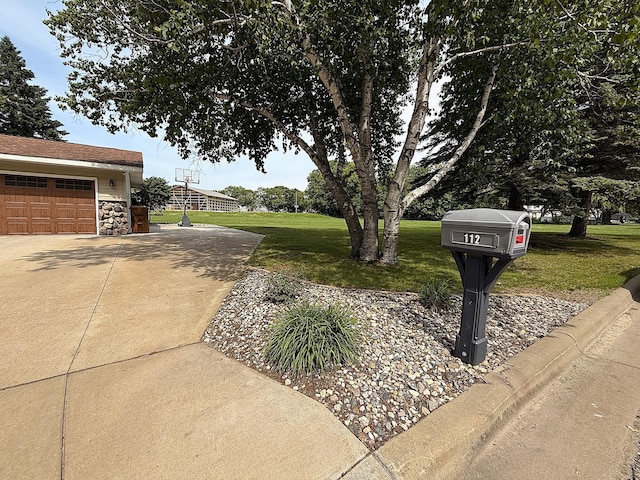 112 Orchard Cir, Montevideo, MN 56265 - view of grassy yard featuring a garage and concrete driveway