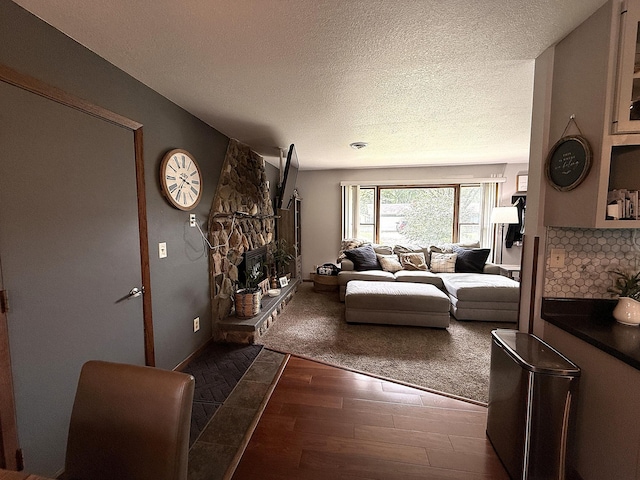 112 Orchard Cir, Montevideo, MN 56265 - living room with a textured ceiling, dark wood-type flooring, and a stone fireplace