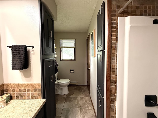 112 Orchard Cir, Montevideo, MN 56265 - bathroom featuring a baseboard heating unit, vanity, a textured ceiling, tile patterned flooring, and a shower