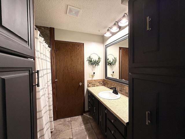 112 Orchard Cir, Montevideo, MN 56265 - bathroom with vanity, decorative backsplash, a textured ceiling, and tile patterned floors