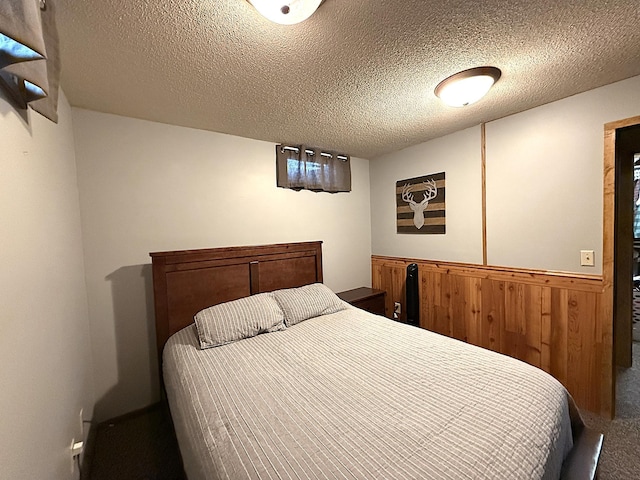 112 Orchard Cir, Montevideo, MN 56265 - carpeted bedroom with a wainscoted wall, wooden walls, and a textured ceiling