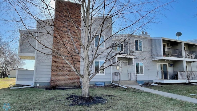 2440 15th St S Unit B14, Fargo, ND 58103 - view of property exterior featuring a balcony, a lawn, and a chimney