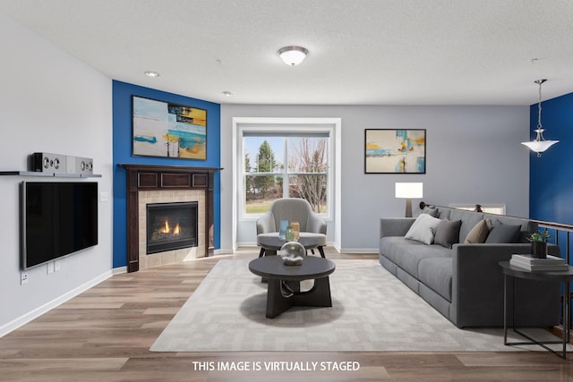 8949 Village Loop, Chanhassen, MN 55317 - living room featuring a tiled fireplace, wood finished floors, a textured ceiling, and recessed lighting