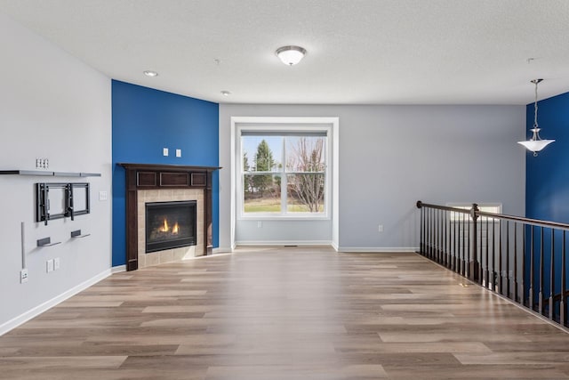 8949 Village Loop, Chanhassen, MN 55317 - unfurnished living room with a fireplace, wood finished floors, recessed lighting, and a textured ceiling