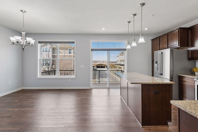 8949 Village Loop, Chanhassen, MN 55317 - kitchen featuring dark wood finished floors, dark brown cabinetry, recessed lighting, a kitchen island, and light stone counters