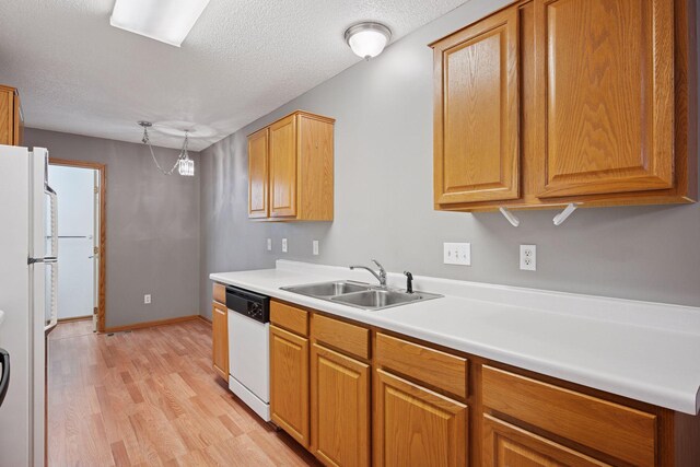 14220 Xenon St NW Unit 6Nw, Ramsey, MN 55303 - kitchen featuring white appliances, light wood-style flooring, light countertops, a textured ceiling, and brown cabinetry