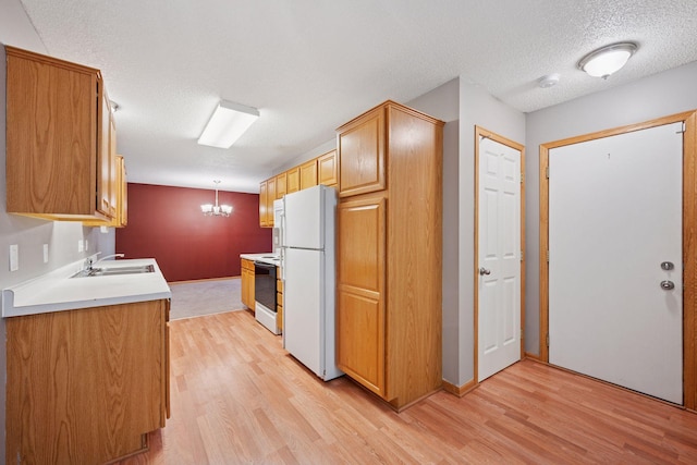 14220 Xenon St NW Unit 6Nw, Ramsey, MN 55303 - kitchen featuring white appliances, light wood-style floors, a chandelier, a textured ceiling, and light countertops