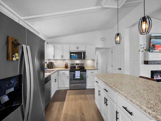 832 10th Ave SE, Forest Lake, MN 55025 - kitchen featuring stainless steel appliances, lofted ceiling, wood finished floors, white cabinetry, and tasteful backsplash