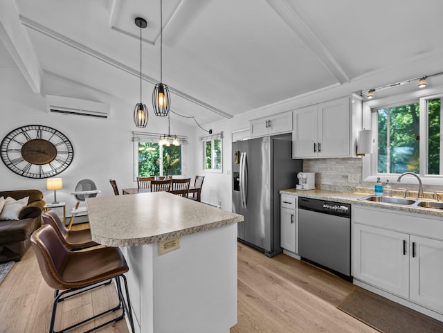 832 10th Ave SE, Forest Lake, MN 55025 - kitchen with stainless steel appliances, a wall mounted air conditioner, light wood finished floors, light countertops, and tasteful backsplash