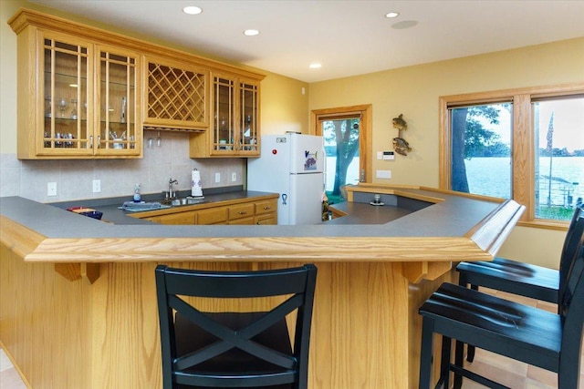 2719 Spring Lake Rd SW, Prior Lake, MN 55372 - kitchen with freestanding refrigerator, tasteful backsplash, recessed lighting, and a breakfast bar