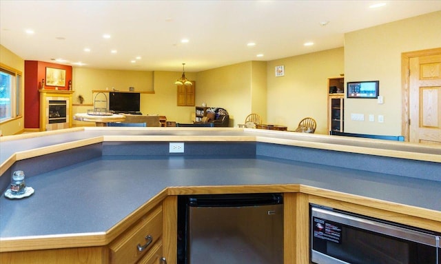 2719 Spring Lake Rd SW, Prior Lake, MN 55372 - kitchen featuring stainless steel microwave, refrigerator, open floor plan, recessed lighting, and a glass covered fireplace