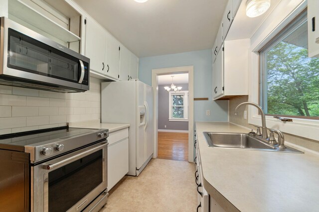 1921 Minneapolis Ave, Duluth, MN 55803 - kitchen with stainless steel appliances, white cabinetry, light countertops, and plenty of natural light