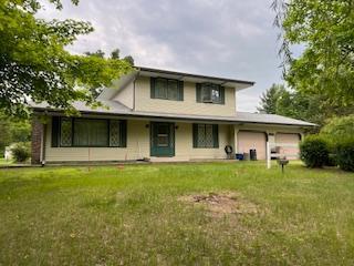 17879 237th Ave NW, Orrock Twp, MN 55309 - back of house featuring a garage and a lawn