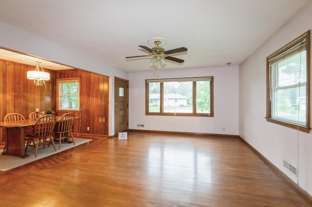1501 100th St, Bloomington, MN 55431 - living area with wood finished floors, a ceiling fan, and wood walls
