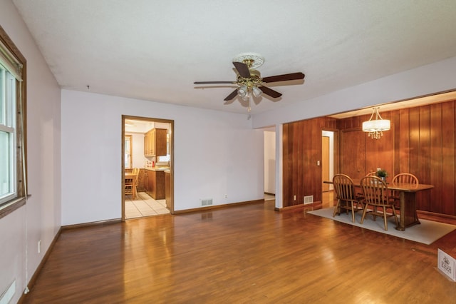1501 100th St, Bloomington, MN 55431 - unfurnished living room featuring wood finished floors, a ceiling fan, and a chandelier