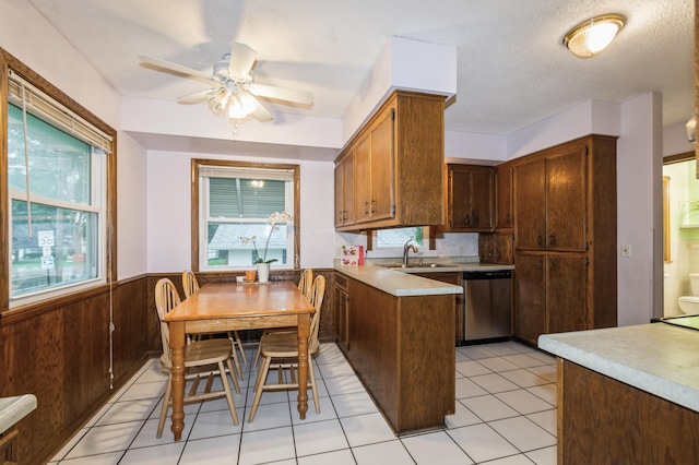 1501 100th St, Bloomington, MN 55431 - kitchen featuring dishwasher, a ceiling fan, a peninsula, light countertops, and wainscoting