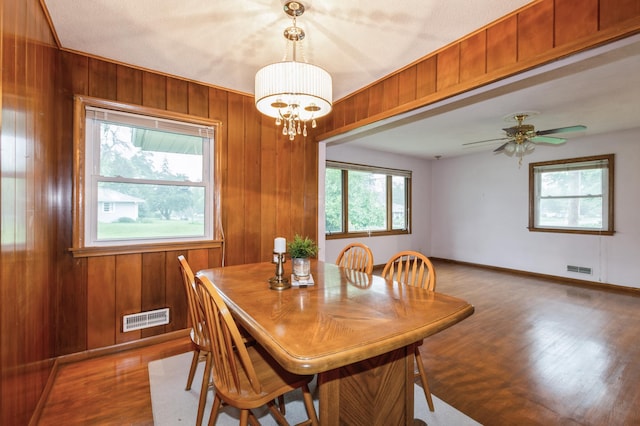 1501 100th St, Bloomington, MN 55431 - dining space featuring wood finished floors, wood walls, a chandelier, and ceiling fan