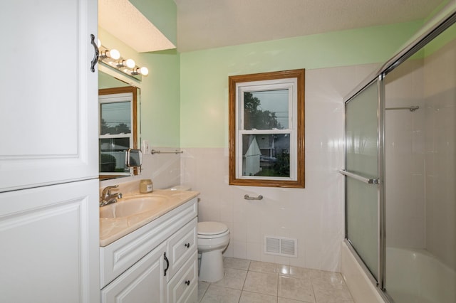 1501 100th St, Bloomington, MN 55431 - full bathroom with tile patterned flooring, vanity, tile walls, shower / bath combination with glass door, and wainscoting