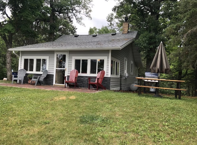 33252 Librarian Ln, Laporte, MN 56461 - rear view of property featuring a chimney, a lawn, and a patio area