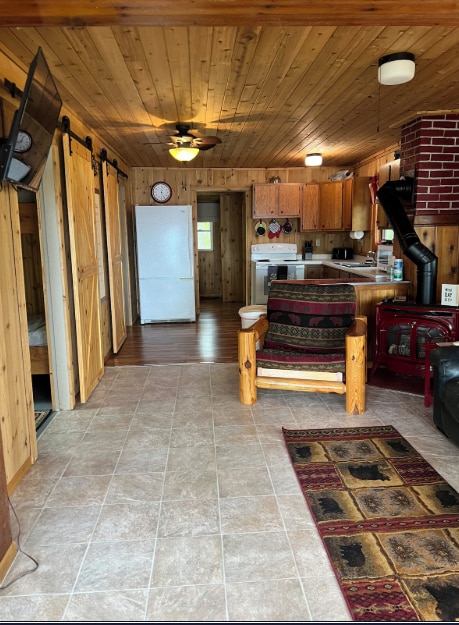 33252 Librarian Ln, Laporte, MN 56461 - kitchen with white range with electric cooktop, a barn door, wooden walls, a wood stove, and wooden ceiling