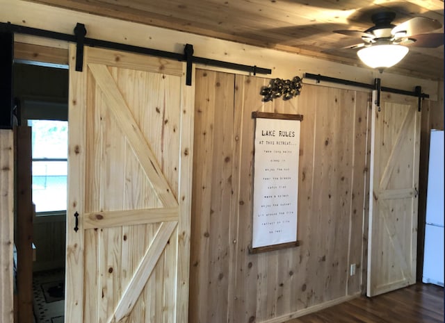 33252 Librarian Ln, Laporte, MN 56461 - detailed view of a barn door, wood walls, wood finished floors, and ceiling fan