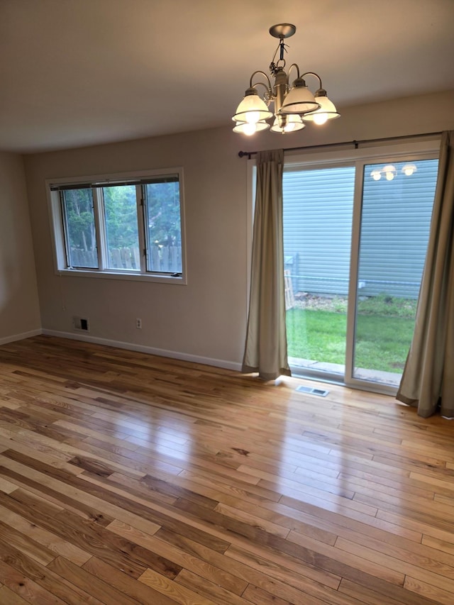 3615 Mckinley St NE, Minneapolis, MN 55418 - unfurnished room with a chandelier and wood-type flooring