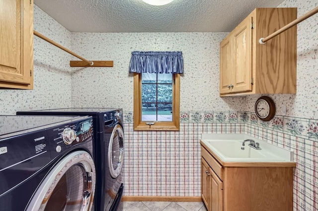 14078 Quince St NW, Andover, MN 55304 - laundry area with wallpapered walls, washing machine and dryer, cabinet space, a textured ceiling, and light tile patterned flooring