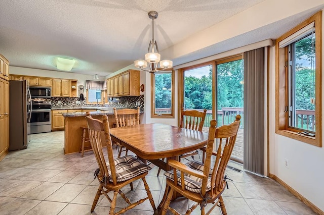 14078 Quince St NW, Andover, MN 55304 - dining space with healthy amount of natural light, light tile patterned flooring, a textured ceiling, and a chandelier