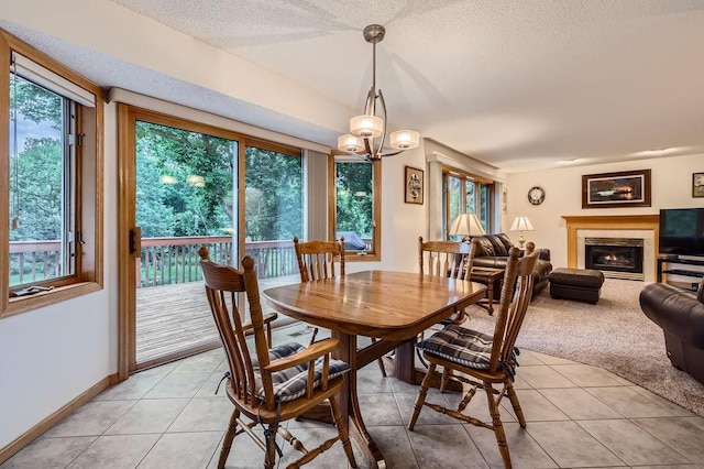 14078 Quince St NW, Andover, MN 55304 - dining room featuring light tile patterned flooring, a glass covered fireplace, a textured ceiling, light carpet, and a chandelier