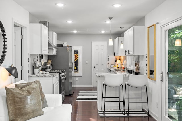 610 34th Ave N, Minneapolis, MN 55412 - kitchen with gas stove, white cabinets, a peninsula, backsplash, and a breakfast bar