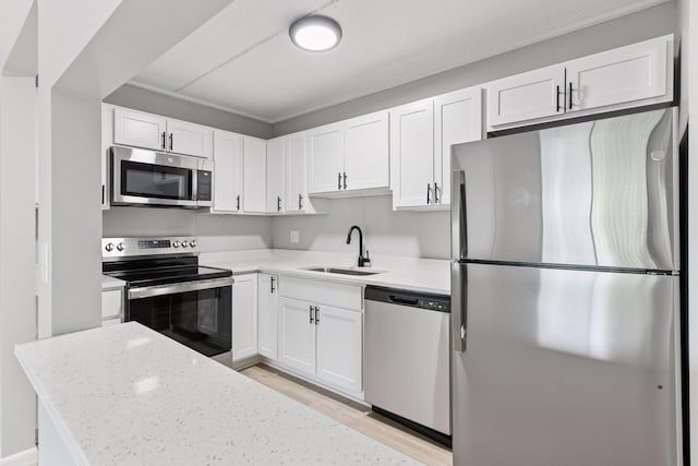 10501 Cedar Lake Rd Unit 515, Minnetonka, MN 55305 - kitchen featuring stainless steel appliances, white cabinets, light wood-style floors, light stone counters, and ornamental molding