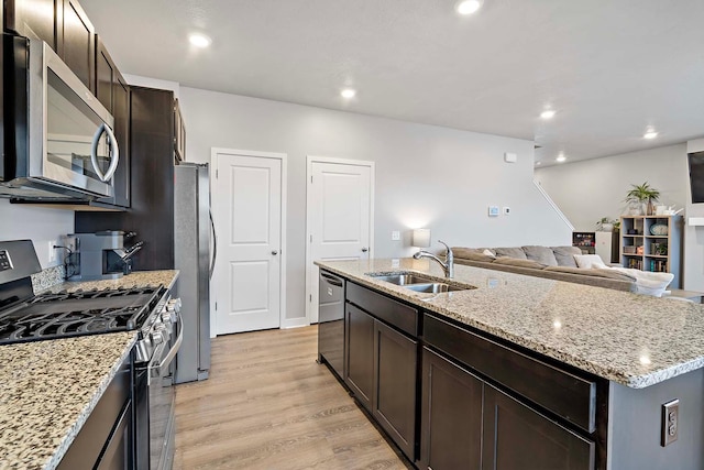 11242 131st Cir N, Dayton, MN 55327 - kitchen featuring appliances with stainless steel finishes, an island with sink, open floor plan, light wood-style flooring, and dark brown cabinetry