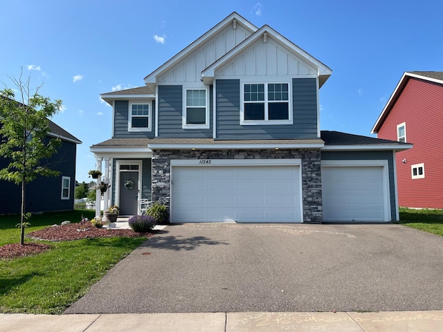 11242 131st Cir N, Dayton, MN 55327 - view of front of home featuring board and batten siding, asphalt driveway, stone siding, an attached garage, and a front yard