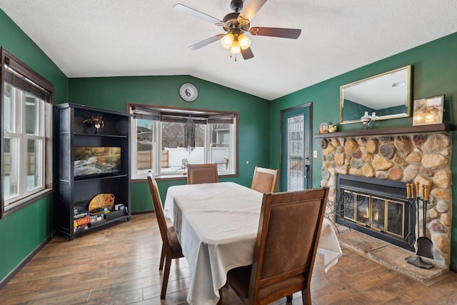 7632 Dupont Ave S, Richfield, MN 55423 - dining area featuring hardwood / wood-style flooring, vaulted ceiling, a ceiling fan, a fireplace, and a textured ceiling