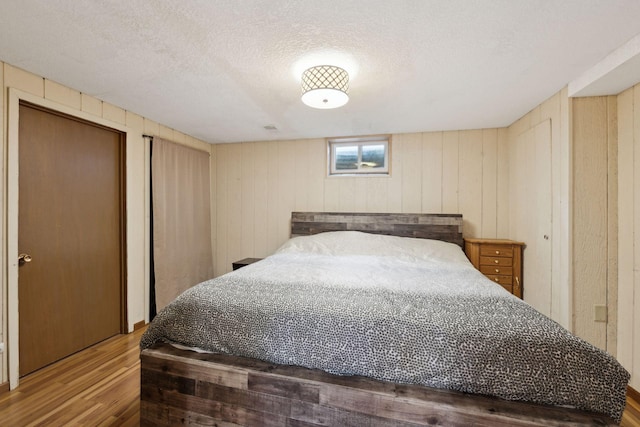 7632 Dupont Ave S, Richfield, MN 55423 - bedroom with wood finished floors, wood walls, and a textured ceiling