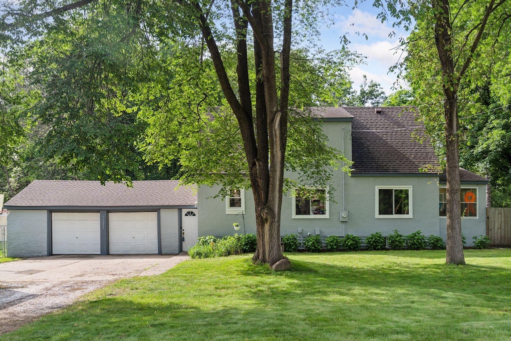 11233 Creek View Ln, Champlin, MN 55316 - view of front of property featuring roof with shingles, driveway, and stucco siding