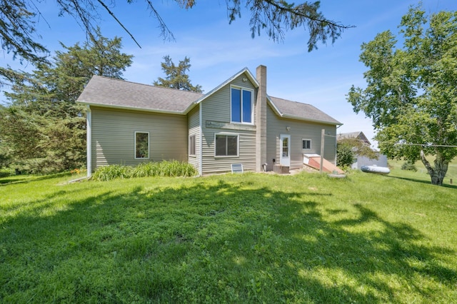 N3752 County Road K, Trenton Twp, WI 54014 - back of house featuring a chimney, a lawn, and a shingled roof