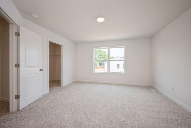 11730 71st St NE, Otsego, MN 55301 - unfurnished bedroom featuring a walk in closet, carpet, and a closet