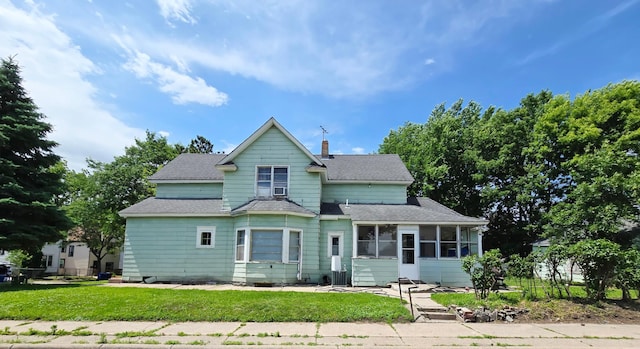 35 Front Ave, Saint Paul, MN 55117 - view of front facade with a sunroom, a shingled roof, a chimney, and a front lawn