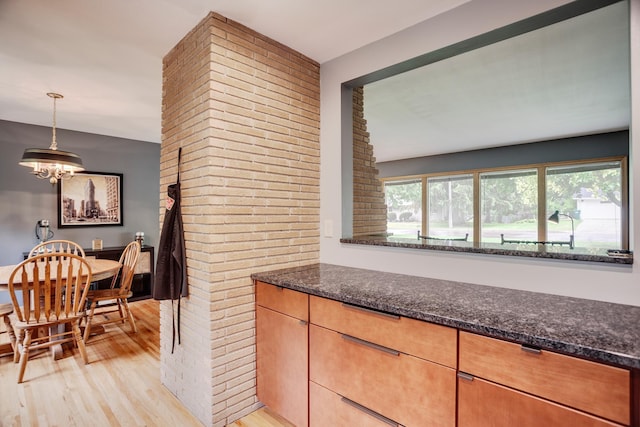 1030 Idaho Ave N, Golden Valley, MN 55427 - kitchen with light wood finished floors, dark stone counters, a chandelier, and hanging light fixtures
