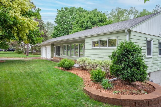 1030 Idaho Ave N, Golden Valley, MN 55427 - view of side of property featuring a yard, a garage, roof with shingles, and driveway