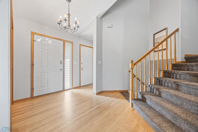 1421 55th Ave S, Fargo, ND 58104 - foyer with a chandelier, light wood finished floors, stairs, and lofted ceiling
