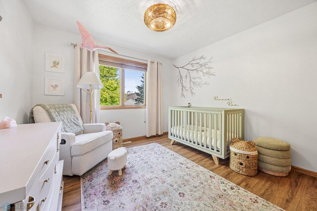 1421 55th Ave S, Fargo, ND 58104 - bedroom featuring a nursery area and wood finished floors