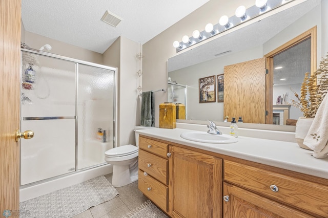 1421 55th Ave S, Fargo, ND 58104 - bathroom featuring vanity, a shower stall, tile patterned floors, and a textured ceiling