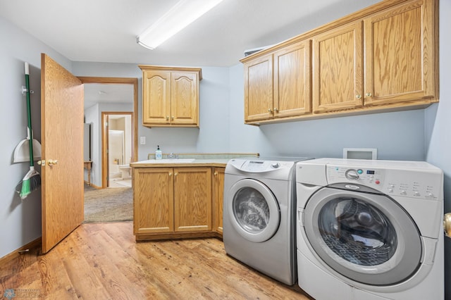1421 55th Ave S, Fargo, ND 58104 - laundry room with cabinet space, separate washer and dryer, and light wood-style floors